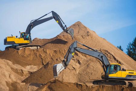 工廠的金屬廢料堆和大型推土機(jī)黃色的重型挖掘機(jī)和推土機(jī)開挖砂和新